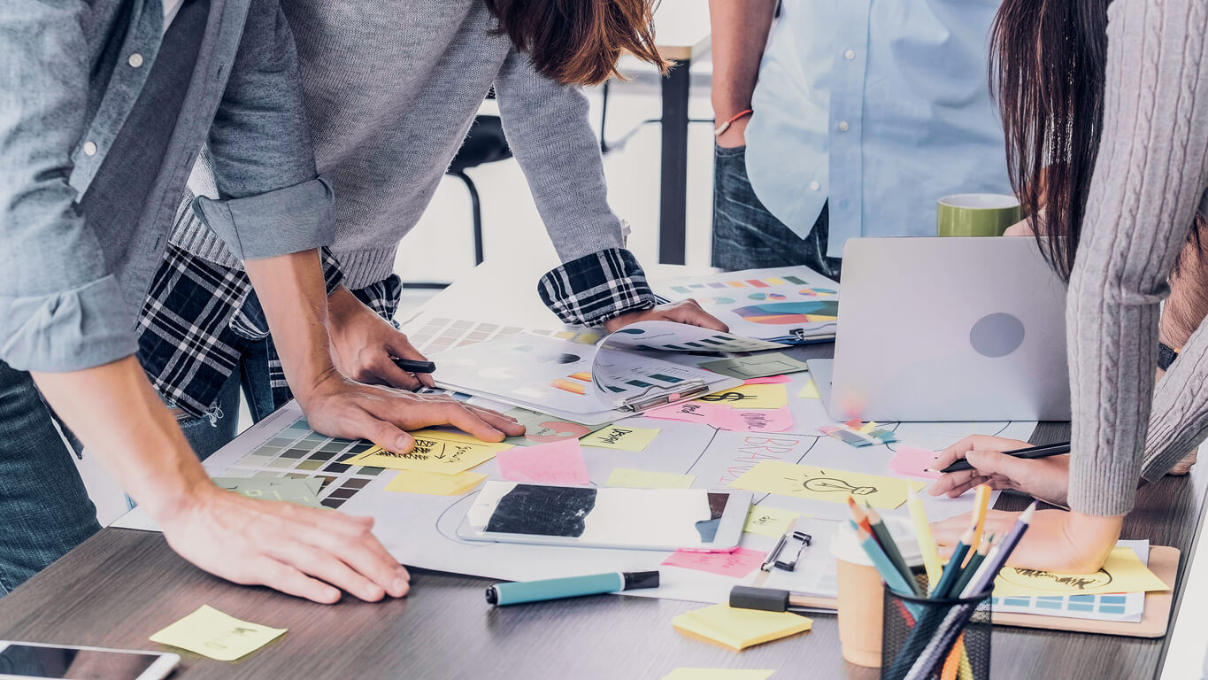 Group of people planning event with papers at desk