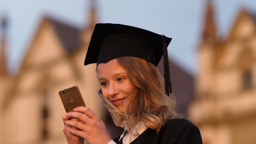 young grad looking at her cell phone
