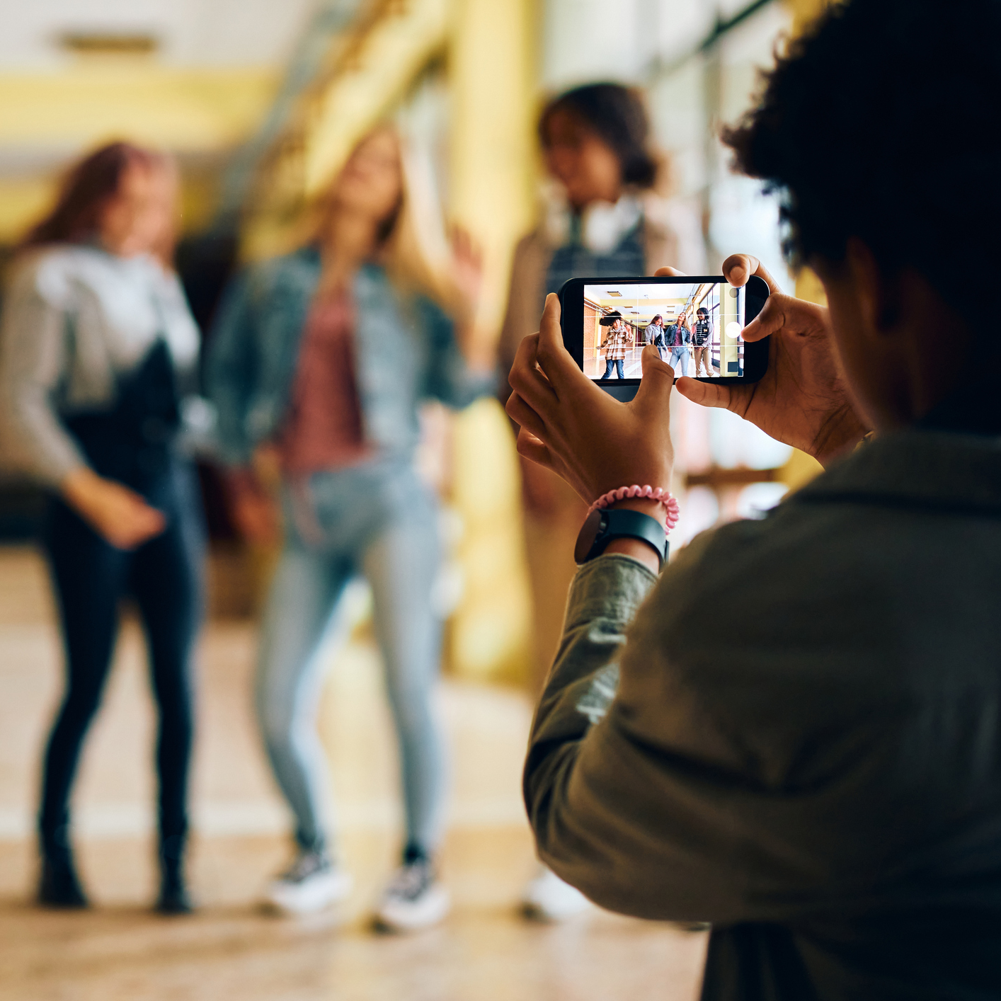 Student recording classmates in a school hallway as part of a campaign video.